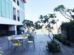 a patio with a table and chairs and trees at Compact Studio Room at Tamansari Papilio Apartment By Travelio in Surabaya