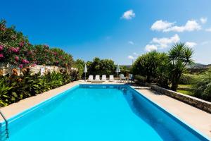 a large swimming pool with chairs and plants at PRINOS in Prínos