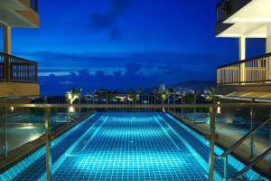 a swimming pool on the roof of a building at night at Princess Seaview Resort & Spa - SHA Plus in Karon Beach