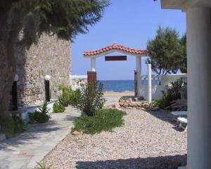 a pathway leading to a building with the ocean in the background at Hotel Agnanti in Ágios Konstantínos
