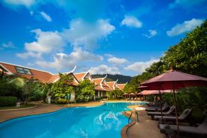 ein Pool in einem Resort mit Stühlen und Sonnenschirmen in der Unterkunft Pattra Vill Resort in Lamai