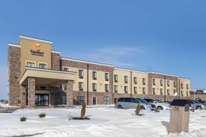 een hotelgebouw met auto's geparkeerd op een parkeerplaats bij Comfort Inn & Suites Cedar Rapids CID Eastern Iowa Airport in Cedar Rapids