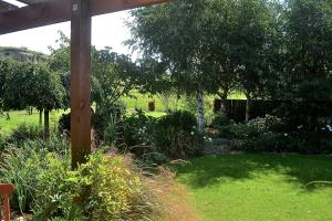 a garden with a wooden pole in the grass at Highlands on Homestead in Oamaru +33 photos