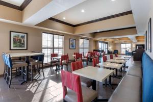een restaurant met tafels, stoelen en ramen bij Comfort Inn & Suites Cedar Rapids CID Eastern Iowa Airport in Cedar Rapids