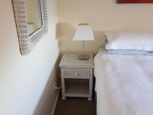 a bedroom with a bed and a lamp on a night stand at tu Emuz Stone Beachfront Villa, Emu Bay, Kangaroo Is in Emu Bay