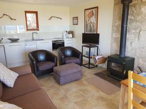 a living room with two chairs and a stove at tu Emuz Stone Beachfront Villa, Emu Bay, Kangaroo Is in Emu Bay