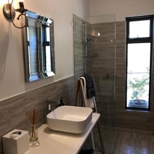 a bathroom with a sink and a shower at Saje's House & Pod in Myrtleford