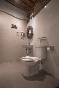 La salle de bains est pourvue de toilettes et d'un lavabo. dans l'établissement Kampung Lawasan Heritage Cottage, à Yogyakarta