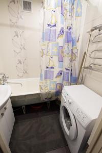 a bathroom with a toilet and a shower curtain at Apartments BastiON in Kyzyl