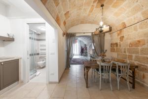 een keuken en eetkamer met een tafel en stoelen bij Eremo Guest House-Housea Travel in Polignano a Mare