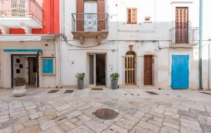 een binnenplaats in een gebouw met blauwe deuren bij Eremo Guest House-Housea Travel in Polignano a Mare