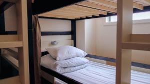 a bunk bed with a pillow on top of it at Peace House Suzunami in Osaka