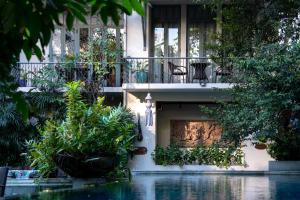 a house with a balcony and a swimming pool at Ariyasom Villa - SHA Extra Plus in Bangkok