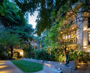 a large building with a tree in the middle of it at Ariyasom Villa - SHA Extra Plus in Bangkok