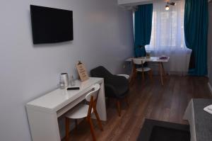 a small room with a desk and chairs and a tv at Aparthotel Danube in Galaţi