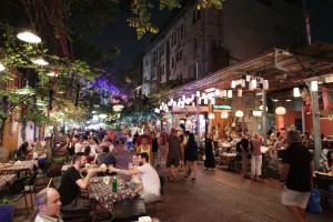 a crowd of people walking around a street at night at Sawasdee House in Bangkok