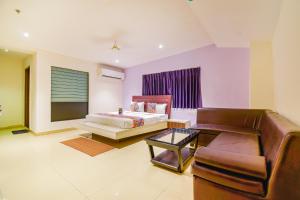 a living room with a couch and a bed at FabHotel Pentagon Airport in Bhubaneshwar