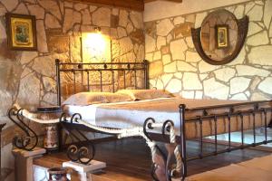 a bedroom with a bed in a stone wall at Petrinolis Retreat in Sitia