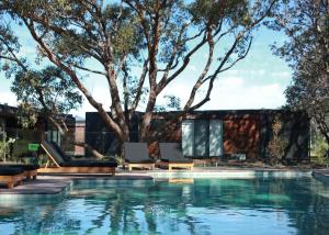a house with a swimming pool with a tree at Bangalay Luxury Villas in Shoalhaven Heads