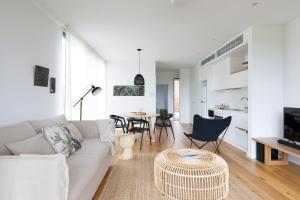 a living room with a couch and a table at Bangalay Luxury Villas in Shoalhaven Heads