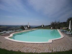 une grande piscine bleue avec des chaises et des parasols dans l'établissement Tenuta Pizzogallo, à Amelia