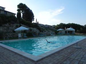 une personne nageant dans une grande piscine dans l'établissement Tenuta Pizzogallo, à Amelia