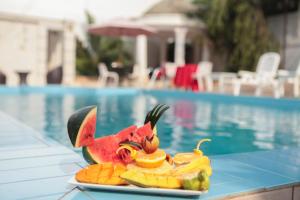 a plate of fruit on a table next to a pool at Hotel Kangaroo Bujumbura in Bujumbura