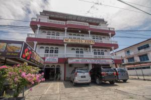 a building with cars parked in front of it at RedDoorz Syariah near Universitas Negeri Padang in Padang