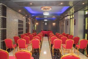 a conference room with red chairs and a table at Hotel Kangaroo Bujumbura in Bujumbura