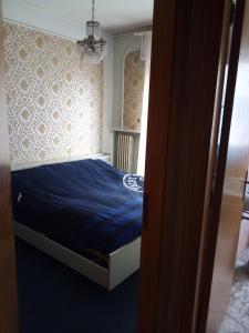 Un dormitorio con una cama azul y una ventana en La Mouette, en Porto San Giorgio