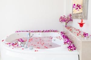 Lux Pool Villas Krabi Ao Nang في شاطيء آونانغ: حمام مع حوض استحمام أبيض مغطى بالشطاف