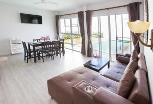 a living room with a brown couch and a table at Lux Pool Villas Krabi Ao Nang in Ao Nang Beach