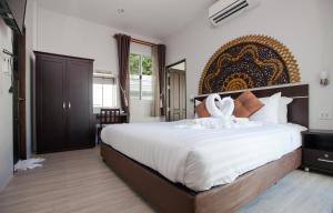 a bedroom with a large bed with swans on it at Lux Pool Villas Krabi Ao Nang in Ao Nang Beach