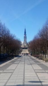 a large street with a clock tower in the distance at Aleja N.M.P 73 in Częstochowa