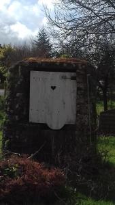 een deur in een stenen muur met een hart erop bij LA LAMBERTERIE : LA BOULANGERIE in Yvetot Bocage