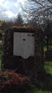 a door in a stone wall with a heart on it at LA LAMBERTERIE : LA BOULANGERIE in Yvetot Bocage
