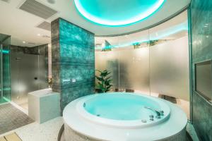 uma casa de banho com uma banheira e um chuveiro em vidro. em Luv U Motel em Kaohsiung