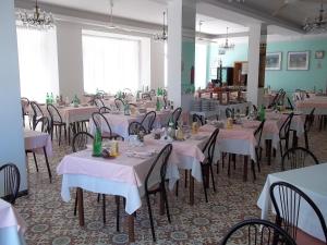 a dining room with tables and chairs with white table cloth at Hotel Italia in Senigallia