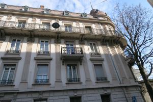 - un grand bâtiment blanc avec des fenêtres et des balcons dans l'établissement Pension Bienvenue (Women only), à Lausanne