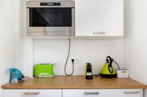 a kitchen with a counter top with a microwave at Nuits étoilées Lourmarin in Lourmarin