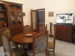 a dining room with a wooden table and a tv at La casa di Mirella in Ne