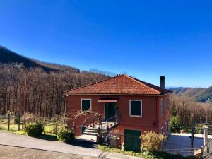 una pequeña casa roja con una valla delante en La casa di Mirella, en Ne