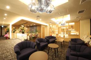 a waiting room with couches and tables and flowers at Compass Hotel Nagoya in Nagoya