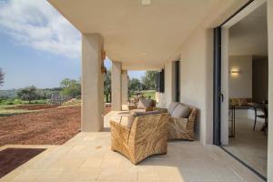 a patio with two couches and chairs on a porch at Piccante Seaview by LoveSud in Patù
