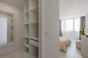 1 dormitorio con paredes blancas y armario con estanterías en Light-Filled, Fully Renovated Apt near Belém, By TimeCooler, en Lisboa