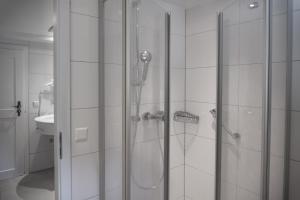 a shower with a glass door in a bathroom at Hotel Restaurant Alatsee in Füssen