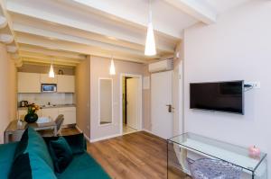 a living room with a green couch and a television at Villa Flores in Dubrovnik