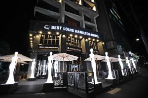 un bâtiment avec des parasols en face de lui la nuit dans l'établissement Best Louis Hamilton Hotel Gwangan, à Busan