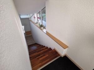 un corridoio con una scala con pavimenti in legno e una finestra di Einzelnwohnung mit eigenem Eingang a Weingarten