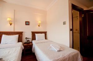 a hotel room with two beds with white sheets at Emine Sultan Hotel in Istanbul